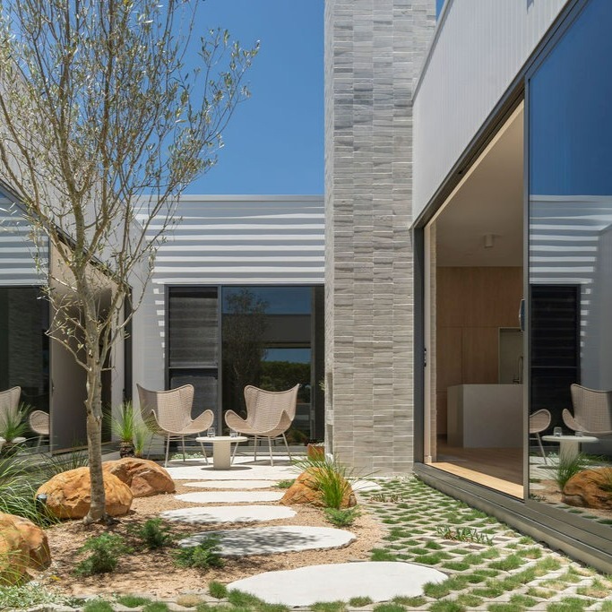 Courtyard home with black aluminium sliding windows and privacy louvres