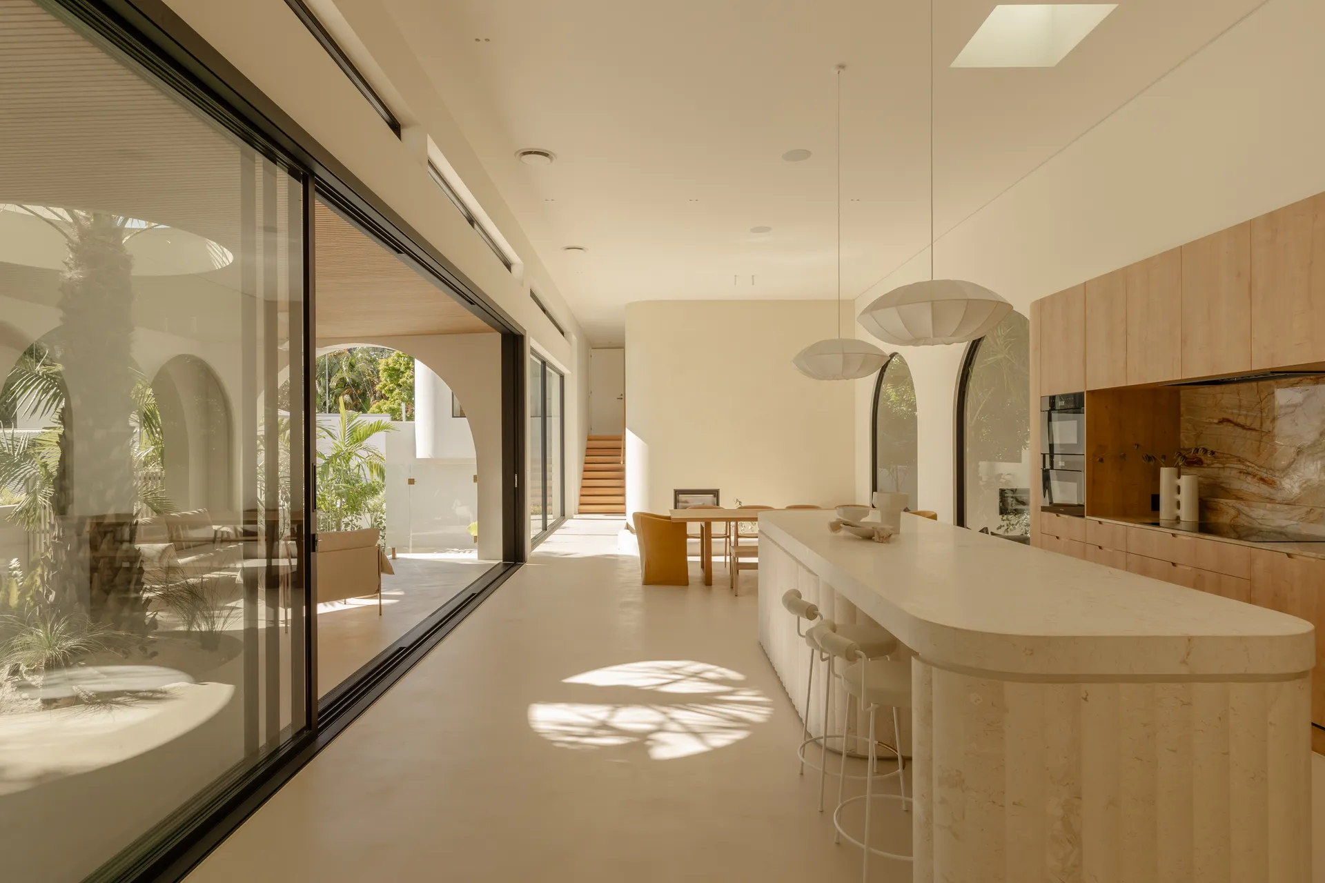 Spacious kitchen opening to a deck through wide AGS aluminium sliding glass doors