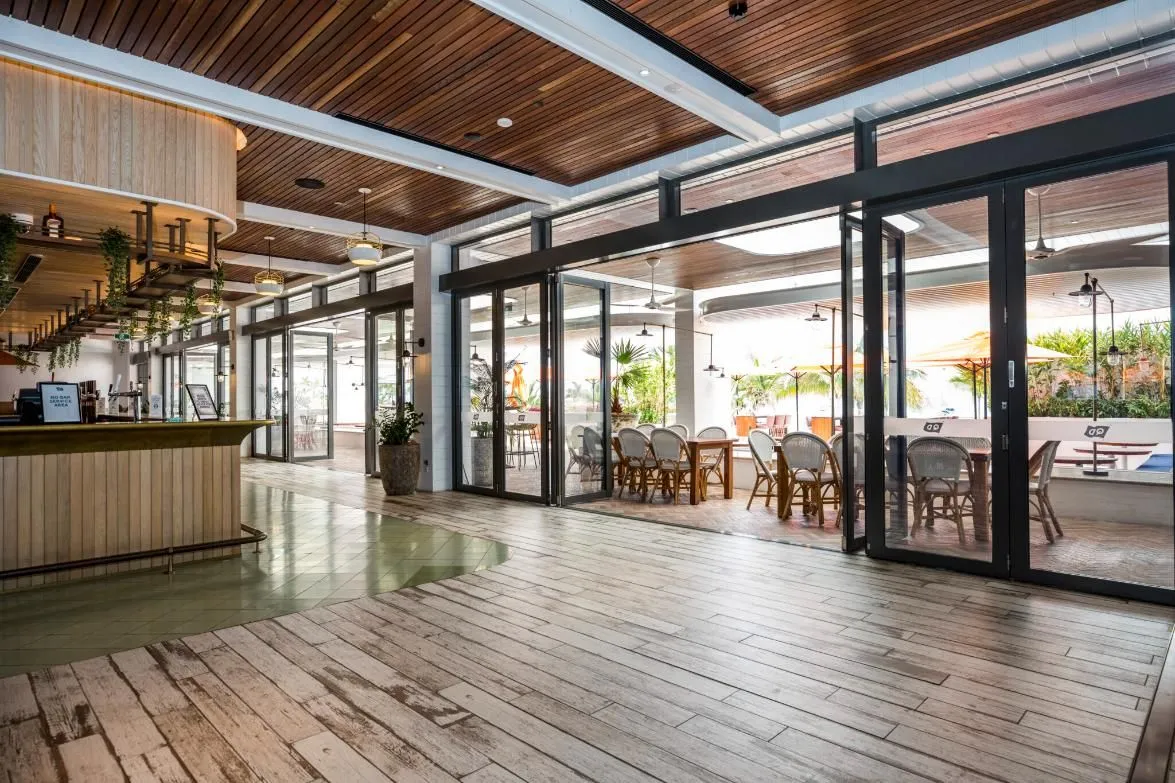 Wide aluminium multi-fold glass doors opened across a hospitality venue frontage